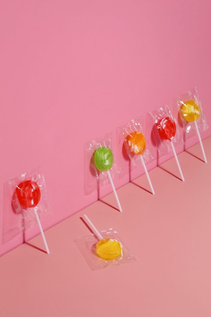 Lollipops Against a Pink Wall and One Lying
