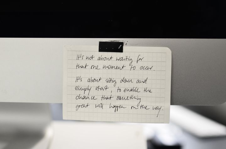 Written text with black words on rectangular shaped paper sheet with square ornament in daylight